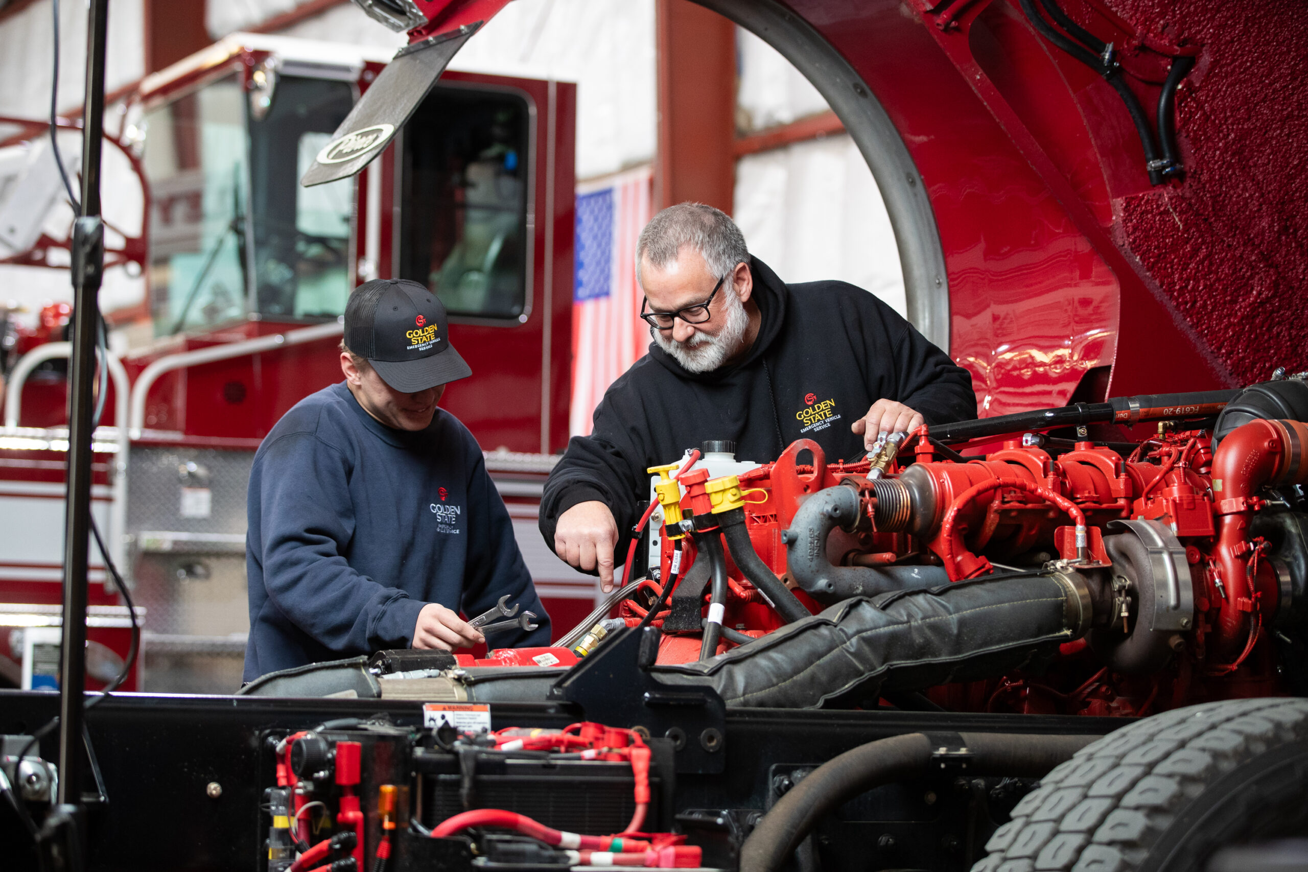mechanics working on a fire truck engine