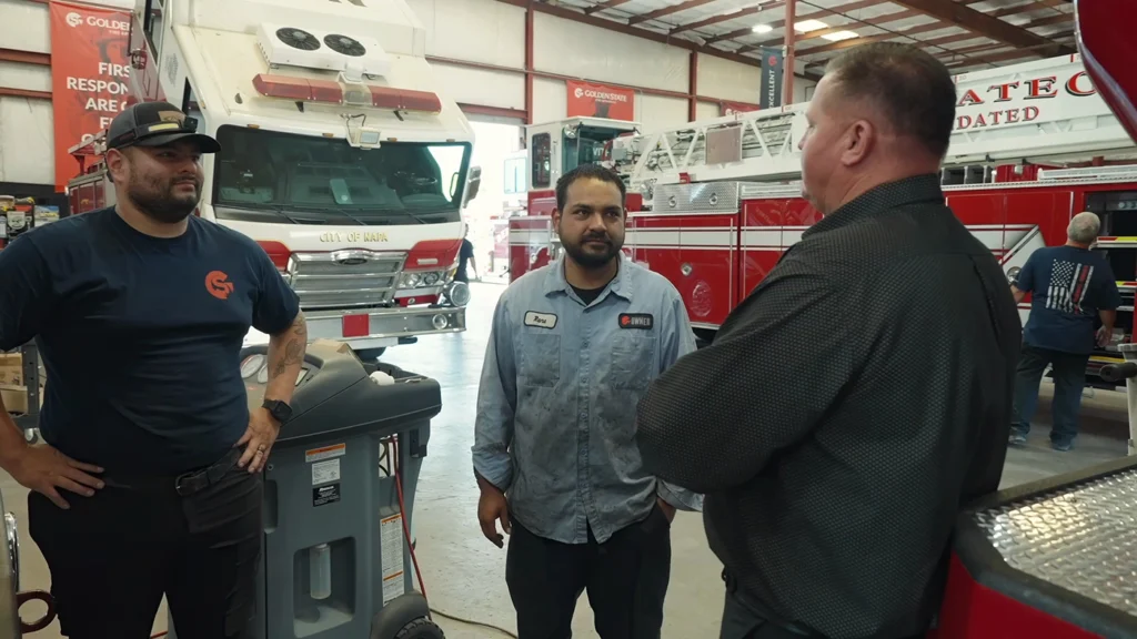 Two employees talking to the owner in the shop